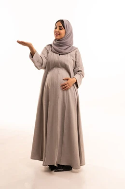 التوضيح والدلالة لمكان محدد، الإشارة إلى عنصر ما, بورتريه لامرأة عربية خليجية سعودية حامل ترتدي العباءة و الحجاب تشير بيديها على الجانب، تحديد موقع شيء معين, صورة الجسم بالطول الكامل، خلفية بيضاء