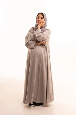 Gestures and facial expressions of boredom and indifference, a portrait of a pregnant Saudi Arabian Gulf woman wearing an abaya and hijab, resting her hand on her chin, waiting for appointments, signs of boredom and indifference, contemplation and focus, full-body shot, white background.