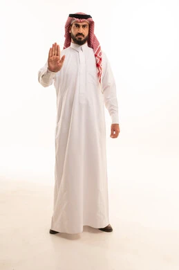 طلب التوقف عن فعل شيء ما، الأمر بالوقوف وعدم التمادي، الرفض وعدم الخضوع، النهي عن التقدم وأهمية ترك مسافة أمان، بورتريه لرجل عربي خليجي سعودي يرتدي الثوب التقليدي والشماغ يرفع كفه للأعلى، الاهتمام بالمظهر الخارجي، الجسم بالطول الكامل، خلفية  بيضاء