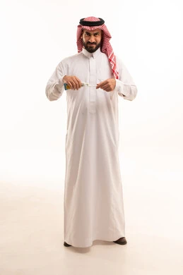 The concept of caring for and maintaining the health and cleanliness of teeth, a portrait of a Saudi Arabian Gulf man wearing a white thobe and a ghutrah, brushing his teeth with a toothbrush and toothpaste, a daily oral hygiene routine, avoiding tooth decay and gum diseases, full body, white background.