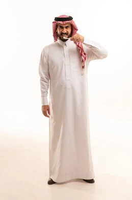 المحافظة على ابتسامة بيضاء، الاهتمام بالأناقة والمظهر الخارجي، بورتريه لرجل عربي خليجي سعودي  يرتدي الثوب الابيض و الشماغ يقوم بتنظيف أسنانه باستخدام الفرشاة ، مفهوم العناية بصحة الفم والأسنان، الجسم بالطول الكامل، خلفية بيضاء