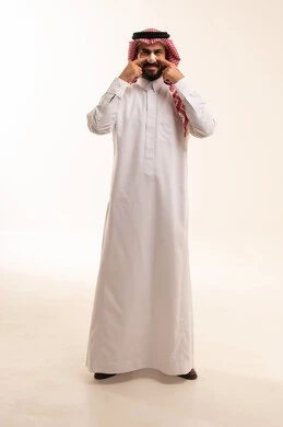 العناية والاهتمام بنضارة وتحسين البشرة، مفهوم العناية بالنفس، التخلص من الرؤوس السوداء والجلد الميت، بورترية لرجل عربي خليجي سعودي يرتدي الثوب الابيض و الشماغ يقوم بوضع لصقات الأنف، استخدام ماسكات تنظيف المسام ومكونات تجميلية، الجسم بالطول الكامل، خلفية بيضاء