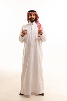 روتين نظافة الأذنين اليومية، استخدام أعواد ونكاشات القطن، العناية والاهتمام بصحة الأذن، بورتريه لرجل عربي خليجي سعودي يرتدي الثوب الابيض و الشماغ يمسك بيدية نكاشة قطنية, الاهتمام بالمظهر الخارجي, الجسم بالطول الكامل، خلفية بيضاء