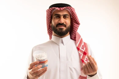 العناية والاهتمام بصحة الأذن، استخدام أعواد ونكاشات القطن، روتين نظافة الأذنين اليومية، بورتريه مقرب لرجل عربي خليجي سعودي يرتدي الثوب الابيض و الشماغ  يمسك بيدية نكاشة قطنية, الاهتمام بالمظهر الخارجي، خلفية بيضاء
