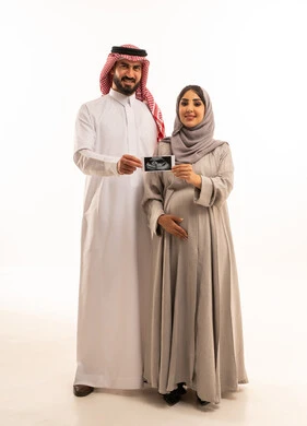 Caring for the health of the fetus, the concept of pregnancy and childbirth, a portrait of a pregnant Arab Gulf Saudi woman wearing a hijab and abaya standing next to her husband holding an ultrasound image, reassurance about the health of the child, full-body, white background.
