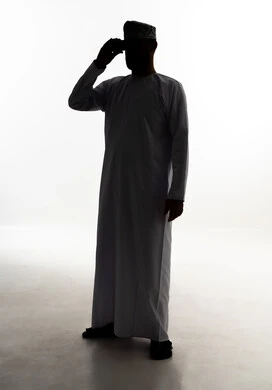 Seeing distant things through a telescope, a love for exploration and adventure, a silhouette of an Arab Gulf Omani man wearing a dishdasha and kumma holding binoculars in his hands, full-body image, white background, silhouette.