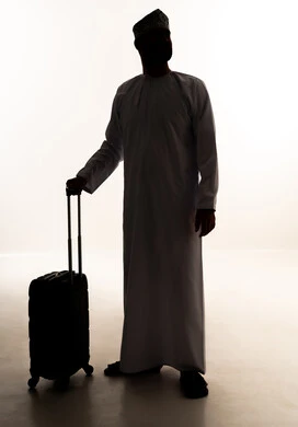 The concept of tourism and travel, taking recreational trips during the summer vacation, looking at something, a silhouette of an Arab Gulf Omani man wearing a dishdasha and kumma carrying a travel bag, preparing for an enjoyable summer trip, full-body image, white background, silhouette.