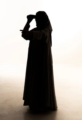 الاشارة الى شيء ما ، حب الاستكشاف و المغامرة، رؤية الاشياء البعيدة عبر التلسكوب, صورة ظلية  لامراه عربيه خليجيه سعودية ترتدي العباءة و الحجاب تمسك بيديها منظار ثنائي العينين, صورة الجسم بالطول الكامل, خلفية بيضاء ، سولوليت