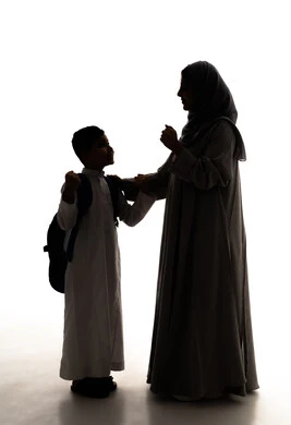 النجاح وتحقيق الأهداف، مفهوم الفرح بالنصر والفوز، موسم العودة للمدارس في السعودية، مفهوم الاعتناء بالأبناء والاهتمام بهم،  صورة ظلية لولد عربي خليجي سعودي يرتدي الثوب الابيض و الحقيبة المدرسية يقف برفقة والدته، الاستعداد للعام الدراسي، الجسم بالطول الكامل، خلفية بيضاء ، سولوليت