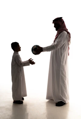 الاستمتاع بممارسة الأنشطة والرياضات الشبابية، مفهوم اللياقة والرشاقة البدنية، مشاركة الأبناء لحظات مرحة، صورة ظلية لرجل عربي خليجي سعودي يرتدي الثوب الابيض و الشماغ يقوم بلعب كرة القدم مع ابنه ، قضاء اوقت ممتعة،الجسم بالطول الكامل، خلفية بيضاء ، سولوليت