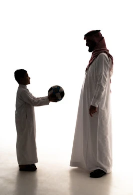 The concept of fitness and physical agility, sharing fun moments with children, enjoying engaging in youth activities and sports, a silhouette of an Arab Gulf Saudi man wearing a white thobe and ghutrah playing football with his son, spending enjoyable time, full-body, white background, silhouette.