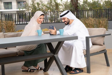 Honeymoon, enjoying hot drinks, Arab man taking a selfie with his wife, gestures of pleasure and happiness, concept of affection and intimacy, having a good time, smiling Emirati Gulf Arab couple sitting in a cafe