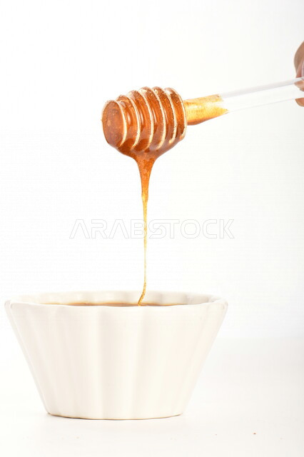 عسل النحل الطبيعي في وعاء زجاجي, ملعقة عسل , عسل النحل الطبيعي الصحي, غذاء صحي , عسل الشفاء