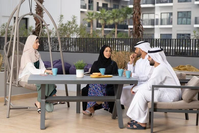 ايماءات السرور والسعادة، التسلية والترفيه بالعطلات ، مفهوم الألفة والمحبة بين أفراد الأسرة، الاستمتاع بشرب المشروبات الساخنه ،انشطة وفعاليات ترفيهية عائلية، أجواء اسرية سعيدة مليئة بالحب، عائله عربيه خليجيه اماراتيه تجلس في المقهى