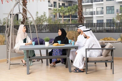 Enjoying hot drinks, family entertainment activities and events, the concept of intimacy and love between family members, a happy family atmosphere full of love, an Arab Gulf Emirati family sitting in a cafe, gestures of pleasure and happiness, entertainment and recreation during holidays.