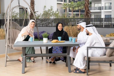 انشطة وفعاليات ترفيهية عائلية، ايماءات السرور والسعادة، التسلية والترفيه بالعطلات،  مفهوم الألفة والمحبة بين أفراد الأسرة، أجواء اسرية سعيدة مليئة بالحب،عائله عربيه خليجيه اماراتيه تجلس في المقهى، الاستمتاع بشرب المشروبات الساخنه