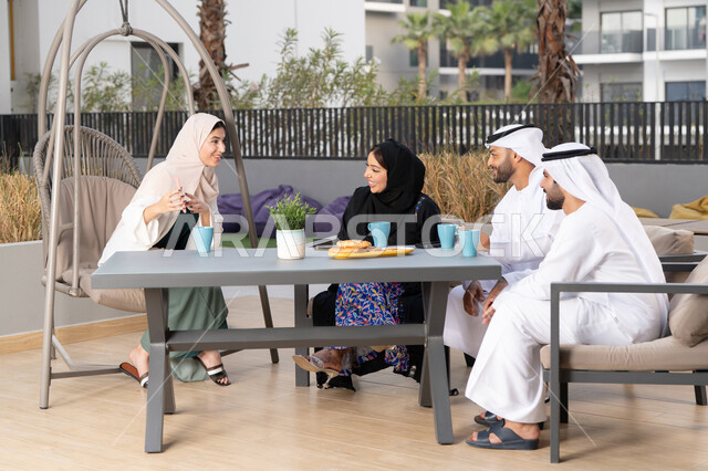 التسلية والترفيه بالعطلات،  مفهوم الألفة والمحبة بين أفراد الأسرة، أجواء اسرية سعيدة مليئة بالحب، انشطة وفعاليات ترفيهية عائلية، ايماءات السرور والسعادة، عائله عربيه خليجيه اماراتيه تجلس في المقهى، الاستمتاع بشرب المشروبات الساخنه