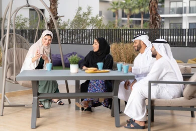 أجواء اسرية سعيدة مليئة بالحب، التسلية والترفيه بالعطلات، انشطة وفعاليات ترفيهية عائلية، مفهوم الألفة والمحبة بين أفراد الأسرة، ايماءات السرور والسعادة، عائله عربيه خليجيه اماراتيه تجلس في المقهى، الاستمتاع بشرب المشروبات الساخنه