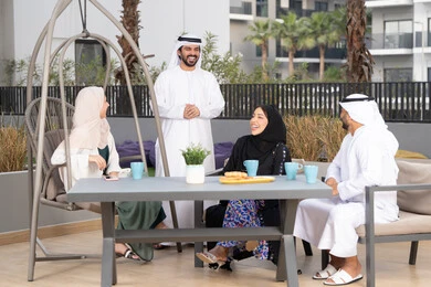 انشطة وفعاليات ترفيهية عائلية، مفهوم الألفة والمحبة بين أفراد الأسرة، أجواء اسرية سعيدة مليئة بالحب، التسلية والترفيه بالعطلات،  ايماءات السرور والسعادة، عائله عربيه خليجيه اماراتيه تجلس في المقهى، الاستمتاع بشرب المشروبات الساخنه