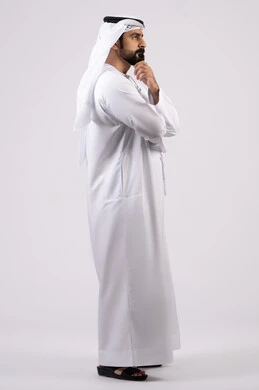 التفكير ومحاولة إيجاد حل للمشكلات, النظر بتمعن والتخطيط للمستقبل, شرود الذهن واتخاذ القرارات بتركيز, بورتريه لشاب عربي خليجي إماراتي يرتدي الغترة والكندورة ينظر إلى شيء ما, خلفية بيضاء