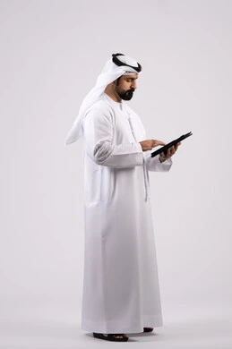 Portrait of an Emirati Gulf Arab man wearing a kandura and ghutra using a tablet, gestures of concentration and integration, use of modern technology, integration of modern technologies in practical life, displaying a blank black screen, full body image, white background