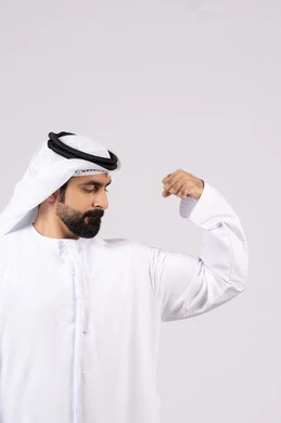 بورتريه لرجل عربي اماراتي خليجي يقوم بعرض العضلات، يقوم بإيماءات يدين تدل على القوة والشجاعة ، بنية جسدية صحية ، مفهوم اللياقة البدنية ،  التمتع بجسم صحي ،  خلفية بيضاء