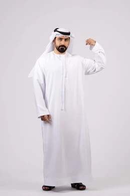 بنية جسدية صحية ، مفهوم اللياقة البدنية ،  التمتع بجسم صحي ،  بورتريه لرجل عربي اماراتي خليجي يقوم بعرض العضلات، يقوم بإيماءات يدين تدل على القوة والشجاعة ، خلفية بيضاء