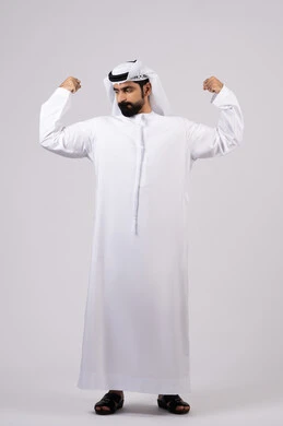 التمتع بجسم صحي ،  بورتريه لرجل عربي اماراتي خليجي يقوم بعرض العضلات، يقوم بإيماءات يدين تدل على القوة والشجاعة ، بنية جسدية صحية ، اللياقة البدنية ، عضلات ، خلفية بيضاء
