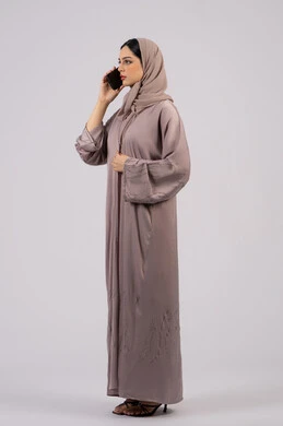 اجراء مكالمات هاتفية ، سيدة اماراتية تعرض شاشة سوداء فارغة ، استخدام التكنولوجيا والتقنية الحديثة، قضاء وقت ممتع عبر الجوال مع الأصحاب، تصفح مواقع التواصل الاجتماعي، بورتريه لامرأة عربية خليجية اماراتية محجبة ترتدي العباءة تقوم بإستخدام الهاتف المحمول، الجسم بالطول الكامل, خلفية بيضاء