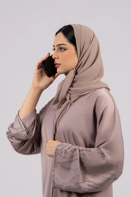 Checking on family, Emirati woman showing blank black screen, using technology and modern technology, having fun on mobile with friends, browsing social networking sites, portrait of a veiled Emirati Gulf Arab woman wearing an abaya using a mobile phone, full body, white background