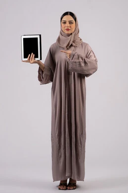 سيدة اماراتية تعرض شاشة سوداء فارغة، ايماءات التفاعل والاندماج , دمج التقنيات الحديثة في الحياة العملية،بورتريه لإمرأة عربية خليجية سعودية محجبة ترتدي العباءة تقوم باستخدام الجهاز اللوحي ،صورة للجسم بالكامل، خلفية بيضاء