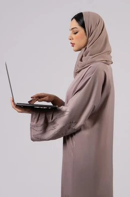 فتاة عربية خليجية اماراتية تقوم بالعمل على الحاسوب المحمول،  اجراء مكالمات الفيديو،العمل لتحقيق الاهداف والاستراتيجيات، سيده سعودية تستخدم الحاسوب المحمول لإنجاز المهام، إدارة شؤون الأعمال وتنظيمها، تصفح الإنترنت وإستخدام اجهزة تقنية حديثة،خلفية بيضاء