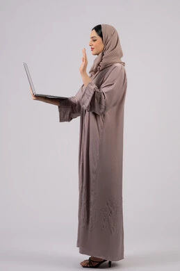 Saudi woman using laptop to complete tasks, greeting via video calls, managing and organizing business affairs, browsing the internet and using modern technology devices, Arab Gulf Emirati girl working on laptop, working to achieve goals and strategies, white background