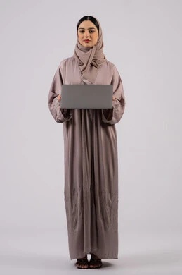 تصفح الإنترنت وإستخدام اجهزة تقنية حديثة، إدارة شؤون الأعمال وتنظيمها، فتاة عربية خليجية اماراتية تقوم بالعمل على الحاسوب المحمول، العمل لتحقيق الاهداف والاستراتيجيات، سيده سعودية تستخدم الحاسوب المحمول لإنجاز المهام،خلفية لكامل الجسم, خلفية بيضاء