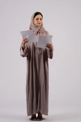 تدوين المهام اليومية ،شابه سعوديه تقوم بالبحث العلمي، قراءة الملاحظات والمعلومات ، متابعة الخطط والمشاريع ،أوراق خاصة بالعمل,بورتريه لامراة عربيه خليجيه اماراتيه محجبه ترتدي العباءة السوداء تحمل بيديها ورقة بيضاء ،  خلفية بيضاء