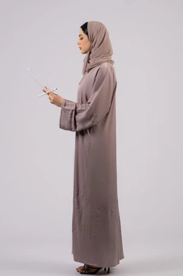 أوراق خاصة بالعمل, تدوين المهام اليومية ،بورتريه لامراة عربيه خليجيه اماراتيه محجبه ترتدي العباءة السوداء تحمل بيديها ورقة بيضاء وقلم، شابه سعوديه تقوم بالبحث العلمي، قراءة الملاحظات والمعلومات ، متابعة الخطط والمشاريع ، خلفية بيضاء