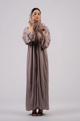 بورتريه لفتاه عربيه سعودية خليجيه ترتدي العباءة والحجاب تحمل بيدها فرشاة توريد الخدود ، صالون نسائي راقي،مفهوم الانوثه والاهتمام بالمظهر الخارجي، سيدة اماراتية تستخدم أدوات تجميل نسائيه عصريه، مكياج وميكاب تتوريال، التسويق لمنتجات التجميل