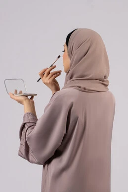 التسويق لمنتجات التجميل ، فتاه عربيه سعودية خليجيه ترتدي العباءة والحجاب تحمل بيدها فرشاة توريد الخدود ، سيدة اماراتية تستخدم أدوات تجميل نسائيه عصريه، مفهوم الانوثه والاهتمام بالمظهر الخارجي، مكياج وميكاب تتوريال، صالون نسائي راقي