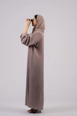 Future planning for goals and ambitions, a young Saudi woman looking at distant objects through a telescope, trying to see something, a side portrait of a veiled Emirati Gulf Arab woman wearing an abaya and hijab looking through a telescope with gestures of amazement and surprise, love of exploration and adventure