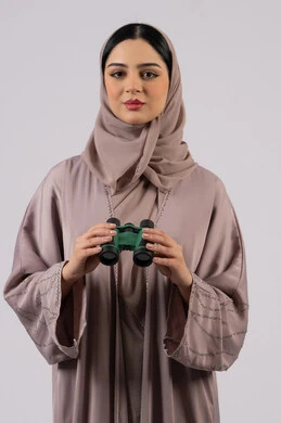 التخطيط المستقبلي للأهداف و الطموحات، حب الاستكشاف والمغامرة، بورتريه لامرأة عربية خليجية اماراتية محجبة ترتدي العباءة والحجاب تنظر من خلال منظار بايماءات الدهشه و الاستغراب, شابة سعودية تقوم برؤية الاشياء البعيدة عبر التلسكوب