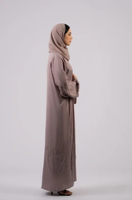 Side portrait of an Emirati Gulf Arab woman wearing an abaya and hijab looking at something, elegance and interest in outward appearance, the concept of femininity and softness, a Saudi girl standing with crossed hands and self-confidence, full body length, white background