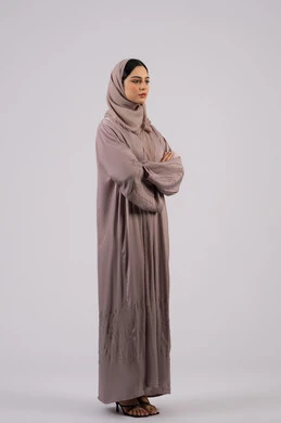 The concept of elegance and interest in outward appearance, a Saudi girl standing with crossed hands and self-confidence, a side portrait of an Arab Gulf Emirati woman wearing an abaya and hijab looking at something, full body length, white background