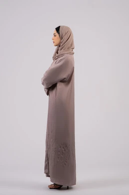 Expressions of seriousness and concentration, side portrait of an Emirati Gulf Arab woman wearing an abaya and hijab looking at something, elegance and interest in outward appearance, the concept of femininity and softness, a Saudi girl standing with crossed hands and self-confidence, full body length, white background