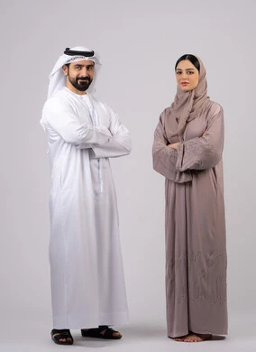 بورتريه  لزوجان عربيان خليجيان إماراتيان يرتديان الزي الاماراتي ينظران إلى الكاميرا ،مفهوم الأناقة والاهتمام بالمظهر الخارجي، الوقوف بايدي متقاطعة وثقة بالنفس،  تعابير الجدية والتركيز، الطول الكامل للجسم، خلفية بيضاء