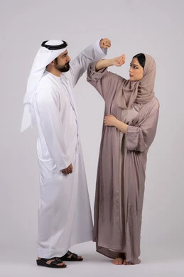 شجار بين الزوجين ، مشاكل عائلية وصراع اسري ،ازمة في العلاقات الاسرية ، رجل اماراتي يضرب زوجته بعنف ، سوء تفاهم بين الازواج  ، بورتريه لزوجان عربيان خليجيان اماراتيان يتجادلان مع بعض، خلفية بيضاء