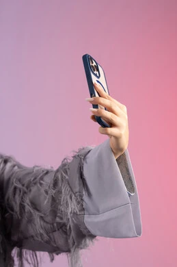 Documenting happy moments on social media, a Saudi woman taking selfies, making a video call via mobile phone, close-up portrait of an Emirati Gulf Arab woman wearing a colorful abaya holding a mobile phone, colorful background