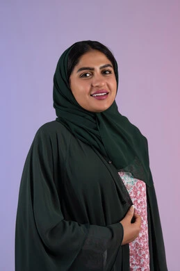 Attention to elegance and outward appearance, the concept of beauty care and a distinguished look, a close-up portrait of a smiling, veiled, Emirati Gulf Arab woman wearing a colorful abaya, a Saudi woman looking at the camera with gestures of happiness and pleasure, colorful background