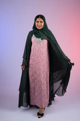 The concept of femininity and taking care of one's appearance, elegant veiled fashion, portrait of an Arab Gulf Emirati woman wearing a hijab and abaya, standing straight with an expression of self-confidence, full-length body, colored background