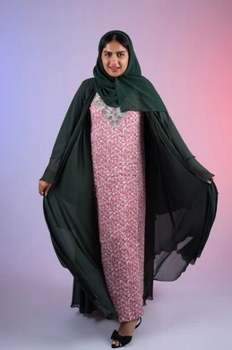 High-end veiled fashion, the concept of femininity and softness, beauty and interest in outward appearance, a Saudi woman looking with gestures of pleasure and happiness, a portrait of an Arab Gulf Emirati woman wearing a hijab and an abaya standing straight with an expression of self-confidence, full-length body, colored background