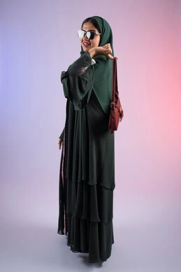 ملابس نسائية عصرية أنيقة، متابعة صيحات الموضة، عرض الأزياء والحقائب والاكسسوارات بالتصاميم الحديثة، التسويق للمنتجات الاماراتية والماركات العالمية، بورترية من الجانب لامراة عربية خليجية اماراتية مبتسمة ترتدي نظارات شمسية عصرية، سيده سعودية تحمل بيدها حقيبة فاخرة, خلفية ملونة